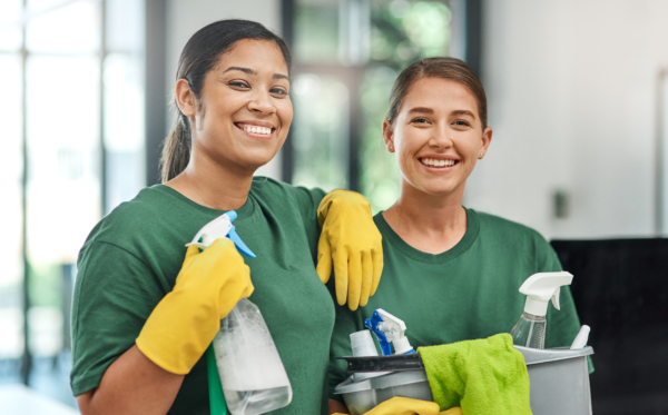 The best team to keep your office clean. Portrait of two young woman cleaning a modern office.
